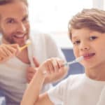 boy and dad brushing teeth